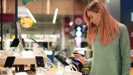 Woman-Chooses-A-New-Smartphone-In-An-Electronics-Store