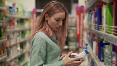 Mujer-Rubia-Lee-La-Etiqueta-De-Productos-Para-El-Hogar-En-El-Supermercado