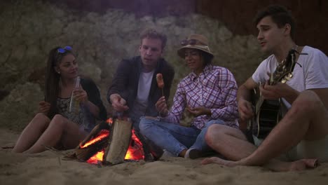 Picnic-Of-Young-People-With-Bonfire-On-The-Beach-In-The-Evening