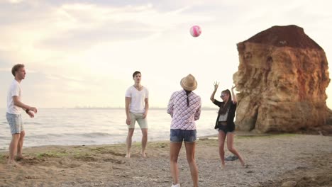 Fröhliche-Junge-Freunde,-Die-Abends-Am-Strand-Am-Meer-Volleyball-Spielen