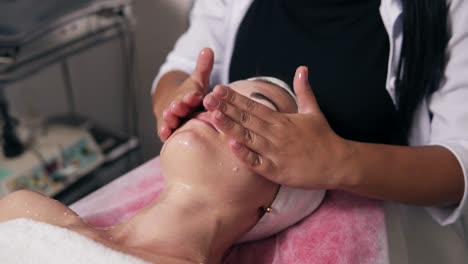 Closeup-View-Of-A-Professional-Cosmetologist's-Hands-Making-Face-And-Neck-Massage-In-Spa-Salon