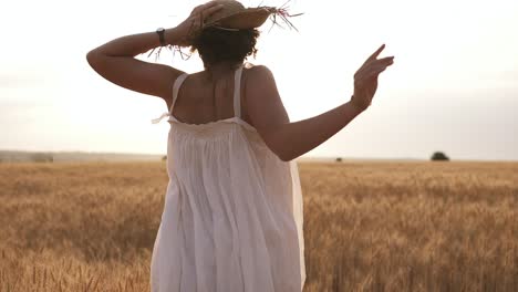 Young-Woman-Running-In-The-Wheat-Field-While-Holding-Her-Straw-Hat