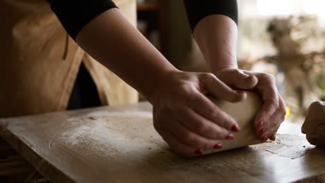 Close-Up-Footage-Of-Female-Hands-With-Beautiful-Red-Manicure-Holding-Clay-And-Kneading-It-On-A-Worktop-2
