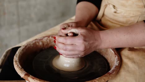 Close-Up-Of-Potter's-Hands-With-Red-Manicure-Working-With-Wet-Clay-On-A-Pottery-Wheel-Making-A-Clay-Product-In-A-Workshop