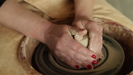 Close-Up-Of-Potter's-Hands-With-Red-Manicure-Working-With-Wet-Clay-On-A-Pottery-Wheel-Making-A-Clay-Product-In-A-Workshop-1