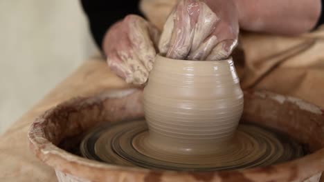 Close-Up-Footage-Of-A-Woman-Sitting-At-Pottery-Wheel-In-Ceramics-Studio-Shaping-Clay-Vase-Shot-In-Slow-Motion