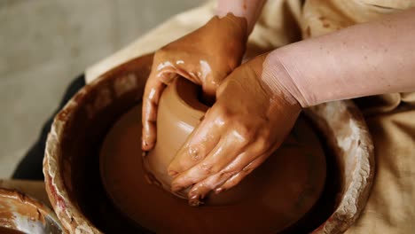 Close-Up-Footage-Of-A-Woman-Sitting-At-Pottery-Wheel-In-Ceramics-Studio-Shaping-Clay-Vase-Diving-Fingers-Inside