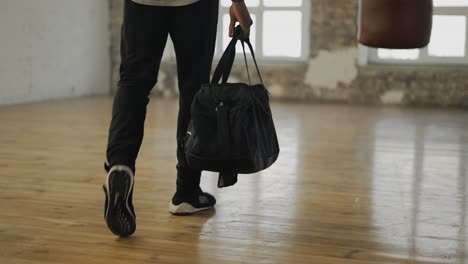 Cropped-View-Of-An-Athlete-Walking-Into-Room-With-A-Bag,-Ready-To-Start-Training