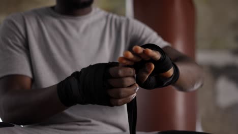 Male-Boxer-Is-Wrapping-Hands-With-Black-Bandage,-Close-Up