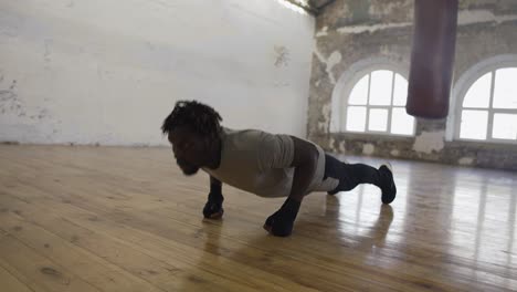 Boxer-Doing-Push-Ups-On-The-Floor-While-Working-Out-In-Old-Light-Building