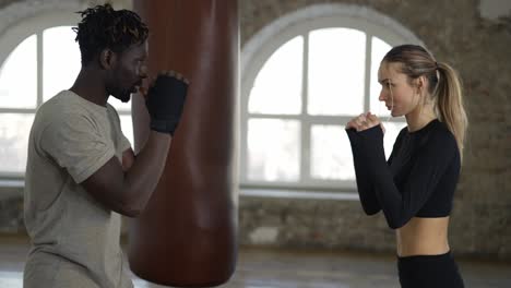 In-A-Spacious-Loft,-Trainer-And-His-Female-Student-Conduct-A-Boxing-Training-Session