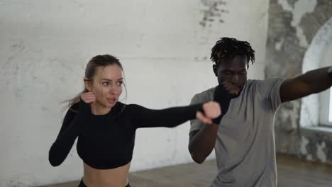 Trainer-And-His-Female-Student-Conduct-A-Boxing-Training-Session,-Practicing-Kicks