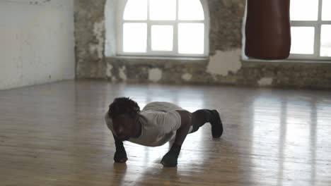 Boxer-Doing-Push-Ups-On-The-Floor-While-Working-Out-In-Old-Light-Building-In-Slowmo