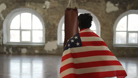 Boxer-Kommt-Mit-Amerikanischer-Flagge-Auf-Den-Schultern-In-Ein-Boxstudio