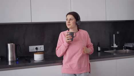 Woman-Listening-To-Music-With-Headphones-At-Home-With-Cup-Of-Coffee