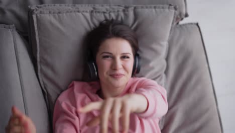 Woman-Relaxing-On-Comfortable-Sofa-Listening-To-The-Music-In-Headphones