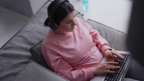 Relaxed-Woman-Working-With-Laptop-Computer-And-Listening-Music-By-Headphone