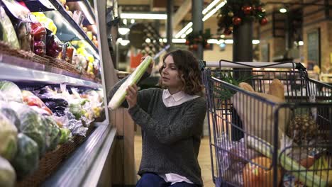 Young-Woman-In-Modern-Supermarket-Choosing-Celery-Leek-In-Organic-Vegetable-Department