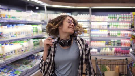 Happy-Young-Girl-Funny-Dancing-Between-Shelves-In-Supermarket