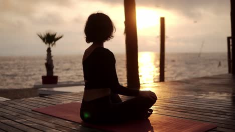 Yogi-Girl-Is-Sitting-In-Lotus-Pose-In-Front-The-Sea-In-Summer-On-Sunset,-Healthy-Lifestyle,-Movement-Concept,-Meditation-Concept