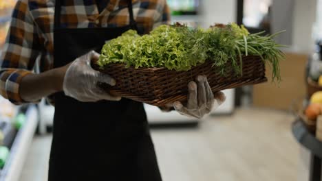 Male-Unrecognizable-Worker-In-Gloves-At-The-Store-Walks-With-Basket-Full-Of-Greens