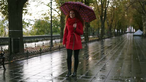 Longitud-Total-De-Mujer-En-Rojo-Caminar-Bajo-La-Lluvia-Con-Paraguas
