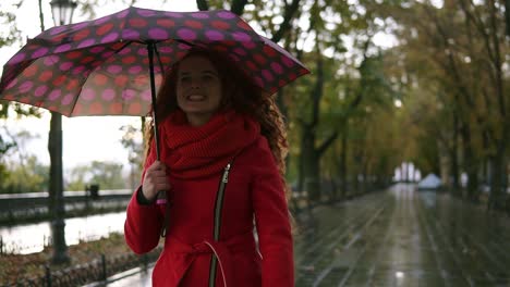 Porträt-Einer-Schönen-Frau-Mit-Rotem-Kopf,-Die-Unter-Regen-Mit-Regenschirm-Spazieren-Geht