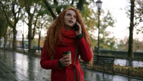 Young-Serious-Girl-Talking-On-Her-Mobile-Phone-On-While-Walking-In-The-Autumn-Park