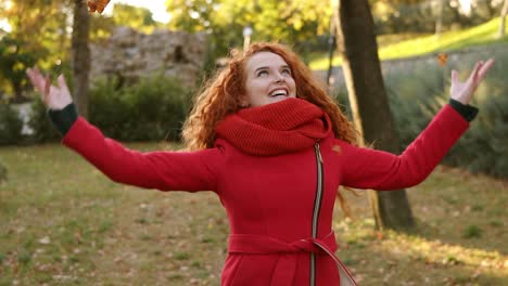 Portrait-Of-A-Happy-Red-Head-Woman-Throwing-Leaves-Around-And-Looking-Up-On-An-Autumns-Day-1
