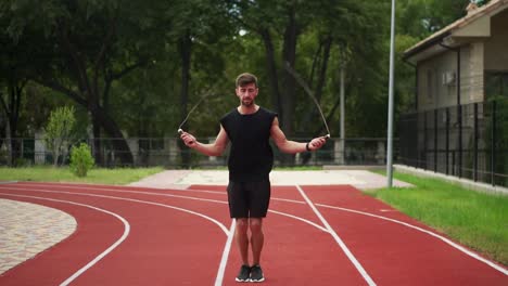 Fit,-Bearded-Man-Standing-On-Running-Track-Outdoors-On-Modern-Stadium-Doing-Exercise-With-Skipping-Rope-In-Slowmo