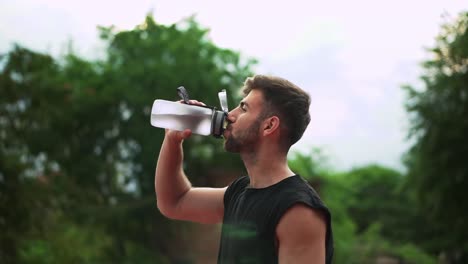 Portrait-Of-Sport-Man-Drinking-Mineral-Water-After-Outdoor-Workout