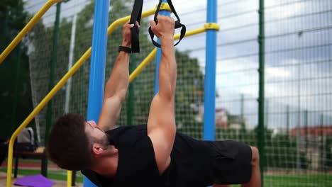 Muscular-Sportsman-Doing-Hanging-Pull-Ups-Exercise-Using-Fit-Belt-To-Force-Strenth-Of-Workout-Outdoors