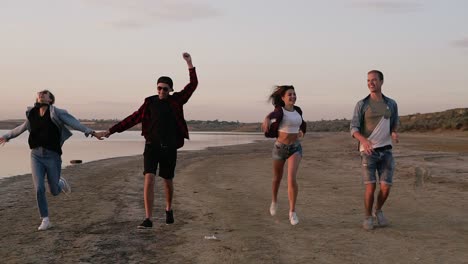 Group-Of-Friends-Running-Happily-Together-On-The-Beach