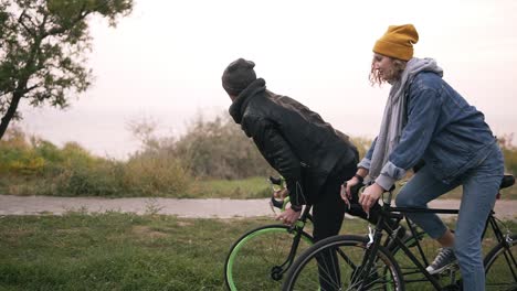Pareja-Joven-Hipster-Disfrutando-De-Andar-En-Bicicleta-Por-El-Parque-En-Bicicletas-De-Trekking-1