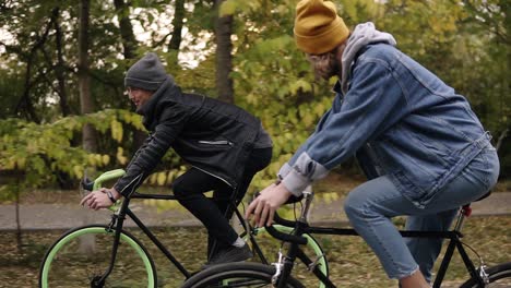Smiling,-Young-Hipster-Couple-Enjoying-Cycling-Through-Park-On-Trekking-Bikes