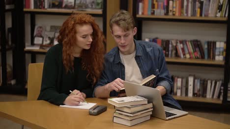 Red-Headed-Girl-And-Handsome-Guy,-European-Students-Study-Together,-Read-Book-In-Students-Library,-Discuss-And-Prepare-For-Exams