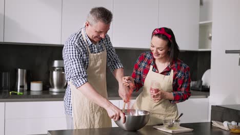 European-Couple-Cooking-Together-With-Fun,-Add-Flavour