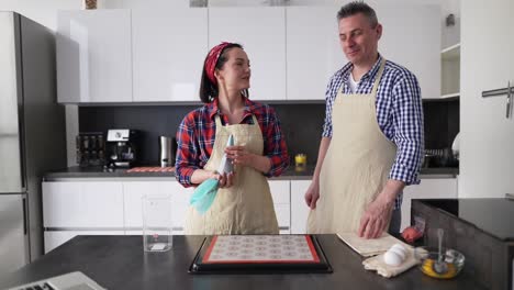 Positive-Couple-At-Kitchen-Making-Macaroons-At-Home,-Talking-On-Camera