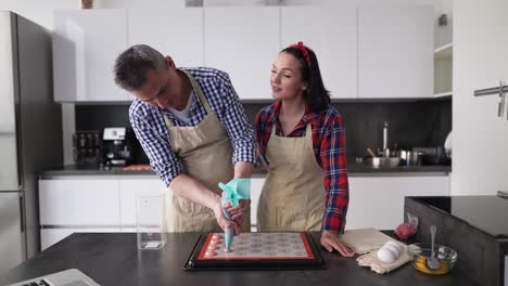 Cheerful-Couple-At-Kitchen-Making-Macaroons-At-Home,-Talking-On-Camera