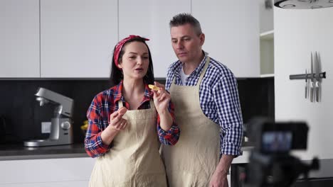 Positive-Couple-At-Kitchen-Baking-At-Home,-Talking-On-Camera