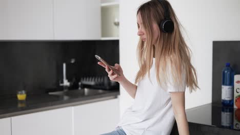 Woman-Listening-To-Music-In-The-Kitchen
