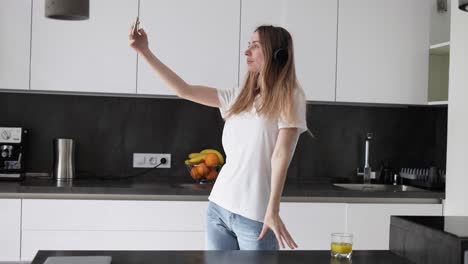 Mujer-Con-Auriculares-Haciendo-Selfie-En-La-Cocina