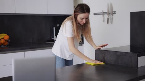 Blonde-Girl-Wipes-Kitchen-Surfaces-On-Kitchen-Counter-With-A-Cloth