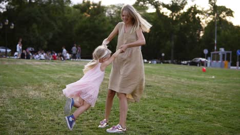 Loving-Mother-In-Beige-Dress-With-Her-Little-Daughter-Having-Fun-And-Playing-In-The-Park