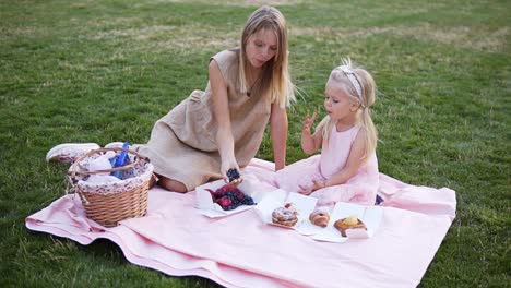 A-Young-Blonde-Woman-And-Her-Baby-Daughter-Are-Eating-Blueberries