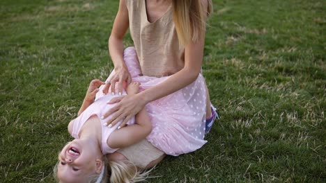 Young-Blonde-Mother-And-Little-Cute-Daughter-Having-Fun-Outdoors,-Playing-Together-In-Green-Park