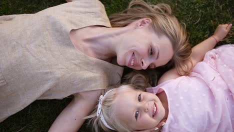 Young-Graceful-Blonde-Woman-With-Her-Little-Blondie-Daughter,-Relaxing-On-Grass-In-Park-1