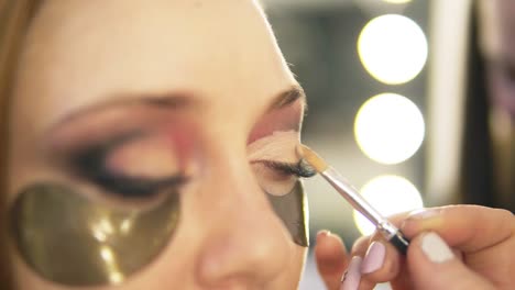 Make-Up-Artist-Putting-On-Light-Eyes-Shadows-On-Model's-Eye