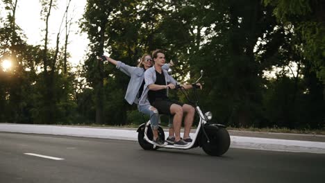 Zwei-Befreundete-Paare-Fahren-Auf-Der-Straße-Auf-Einem-Elektro-Minibike