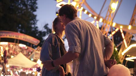 Low-Angle-View-Of-A-Gorgeous-Young-Couple-In-Amusement-Park-At-Night